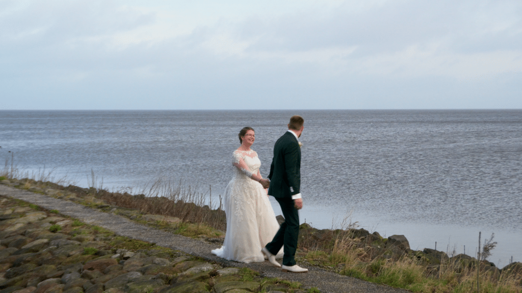 Bruid en bruidegom aan het water tijdens huwelijks foto